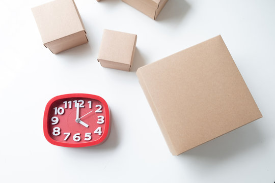 Ecommerce and delivery service in time :cardboard box with a red clock on white desk in office, Product pack, Delivery, Deadline, Online shopping Concept.