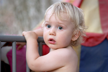 Beau bébé blond aux yeux bleus avec un regard etonné