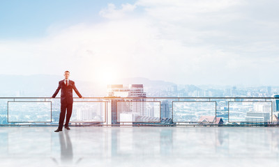 Sunrise above skyscrapers and businessman facing new day