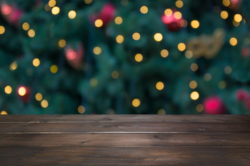 Wooden dark tabletop and blurred christmas tree bokeh. Xmas background for display your products.