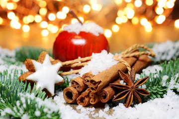 Moody Christmas scene with wooden apple, cinnamon sticks, cinnamon stars, anise stars, fir...