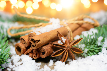 Obraz na płótnie Canvas Cinnamon sticks as a spice for Christmas with fairy lights as decoration and lighting