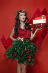 Beautiful model holding gifts and wearing xmas tree costume