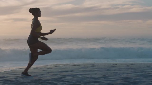 young woman athlete running on beach at sunrise exercising female runner sprinting training in seaside