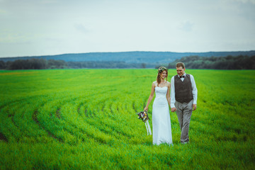 bride and groom stand on the background of the field