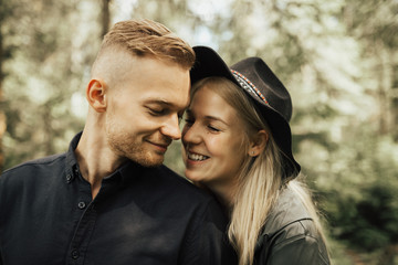 Portrait of hipster couple on the top of mountains enjoying mountains and clouds landscape. Love and travel concept. Lifestyle concept. family active traveling. Mountain view