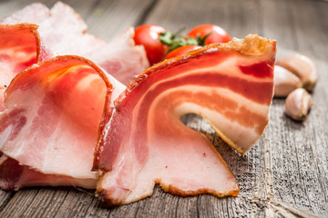 Slices of bacon on the wooden background