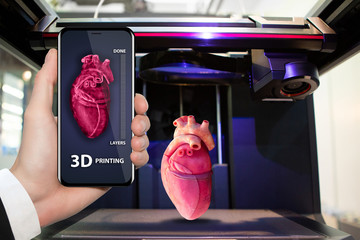 Hand with phone. Application for printing human organs in a 3D printer.