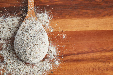 Organic buckwheat flour in wooden spoon on table. Top view with copy space