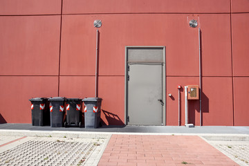 emergency exit with garbage bin at the industrial buiding .