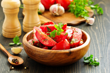 Appetizer of salted tomato with garlic and herbs.