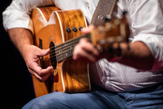 Man playing a guitar on stage (shallow DOF; color toned image)