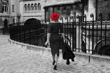 Young woman walking in Montmartre, Paris. Black and white photo with isolated red colour. 