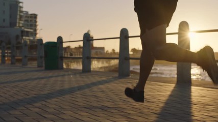 fit young man running fast athlete training endurance runner jogging cardio exercise workout on calm ocean seaside at sunset