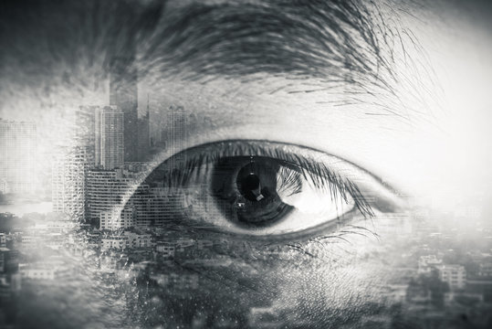 The double exposure image of the businessman's eye overlay with cityscape image. The concept of modern life, futuristic, technology, iris scanner and internet of things.