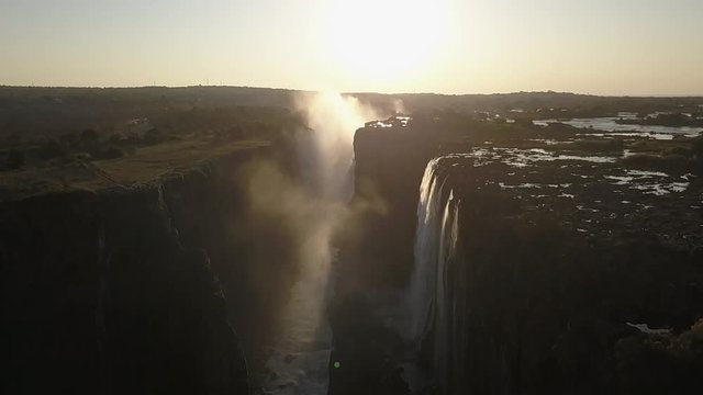 Aerial view of mountain tops with a sunset and waterfall