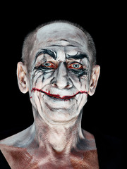 Obraz premium Bloody Halloween theme: The crazy maniak face on dark studio background