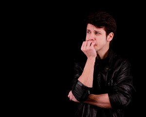 Handsome young man thinking in front of black background