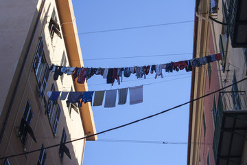 Panni stesi ad asciugare tra due palazzi in un quartiere di periferia a Genova, Italia