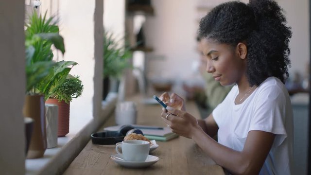 happy african american woman using smartphone in cafe browsing online messages enjoying sharing lifestyle on social media relaxing in coffee shop restaurant