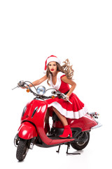 Fototapeta na wymiar beautiful young woman in santa costume driving red scooter, isolated on white