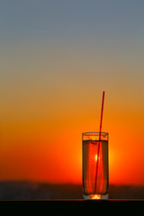 Glass beaker with water at sunset