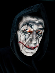 Bloody Halloween theme: The crazy maniak face on dark studio background