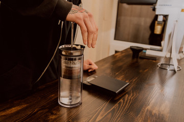 Making coffee in the American press. Hot drink. Welding coffee with the help of pressure and wetting the grain in the filter. Hot glass kettle with boiling water. Coffee house.