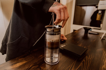 Making coffee in the American press. Hot drink. Welding coffee with the help of pressure and wetting the grain in the filter. Hot glass kettle with boiling water. Coffee house.