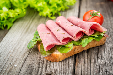 sandwich with ham and vegetables. Organic products on a wooden table