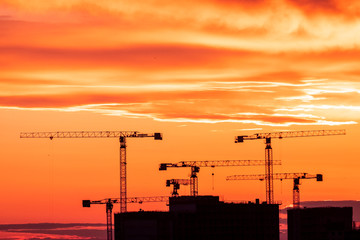 Crane and building silhouettes at sunrise