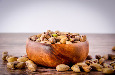 nuts in a bowl on wooden background