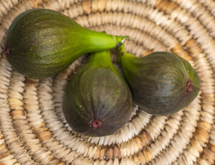 Close-up of ripe Brown Turkey variety figs on a woven mat