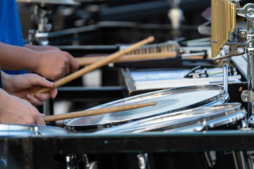 flashing drumsticks of a sideline percussionist at marching band rehearsal