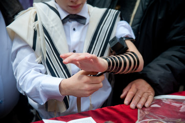 young jew boy praying tfilin near western wall in talit after his barmitzvah