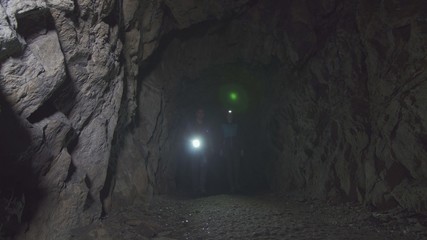 Obraz premium man and woman go with lanterns in the cave