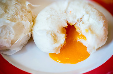 Chinese steamed bun and orange sweet creamy lava on chinese pattern dish. Dimsum Chinese famous food.