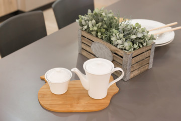 Beautiful white tea-set on the wooden plank at the kitchen