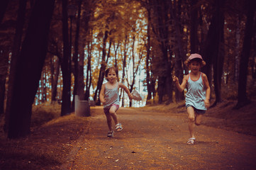 Fototapeta premium Two girls are running around the park, who is first