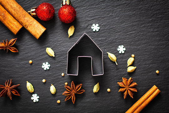 Holiday Food background Christmas cookies cutter spices Star anise, cloves and cadamon pods on black slate board