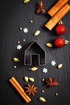 Holiday Food background Christmas cookies cutter spices Star anise, cloves and cadamon pods on black slate board