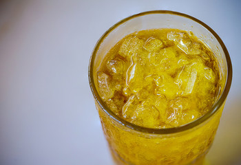 Close up glass of ice with yellow drink, boiled Chrysanthemum, nature herb water, low sugar drink. Soft and blur style