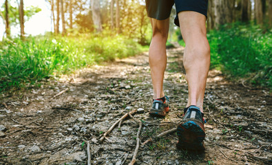 Detail of feet of young man participating in a trail race through the forest