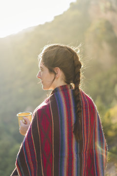 Spain, Alquezar, woman with braid and coffee mug at backlight
