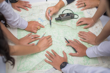 hands on the map from top view