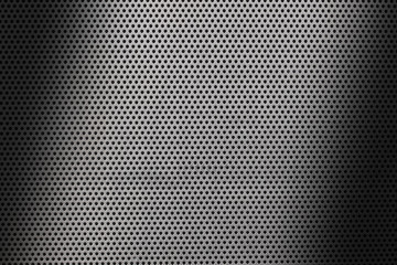 close up on a metalic shhet texture with small holes and shades.
