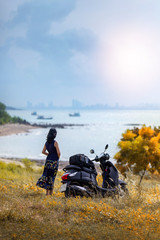 The traveler standing on the hill of the island looking at the sea