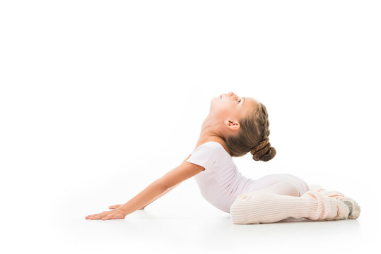 side view of little kid doing gymnastics exercises isolated on white background
