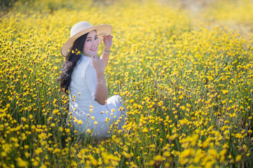 Fototapeta premium pretty woman in the white dress at yellow flowers field