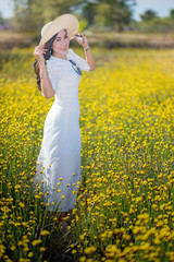 pretty woman in the white dress at yellow flowers field